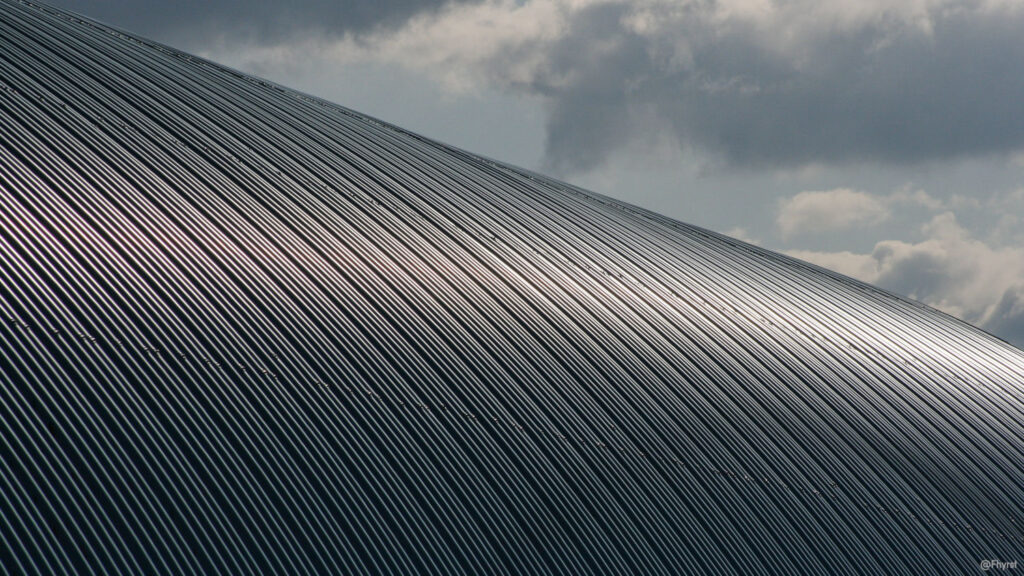Metallisches Dach und Wolken im Hintergrund.