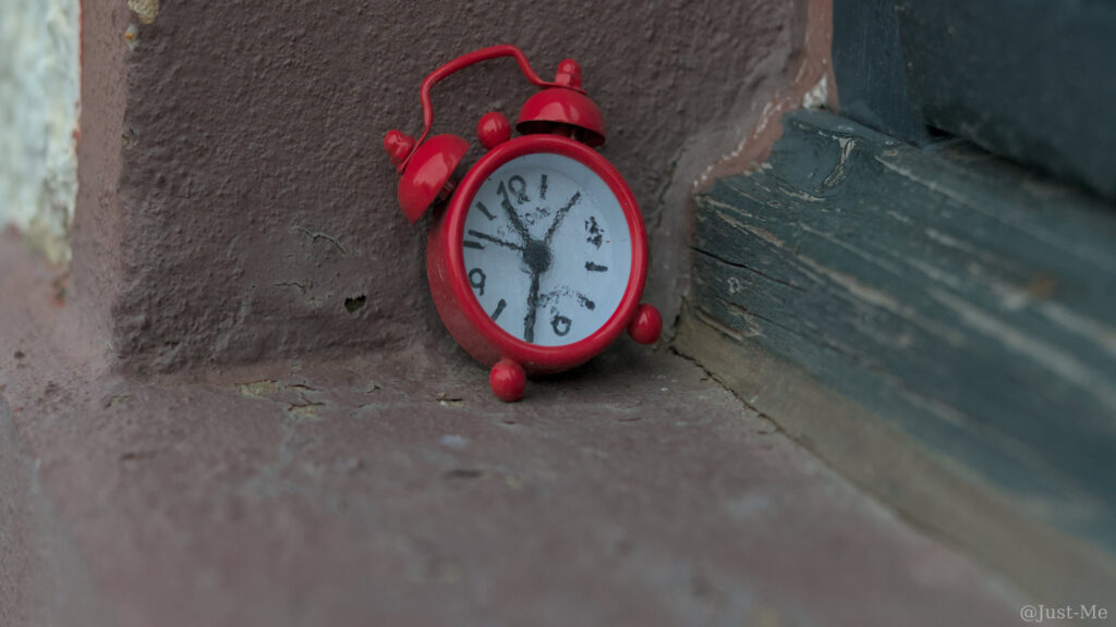 Roter Wecker vor einem Fensterrahmen