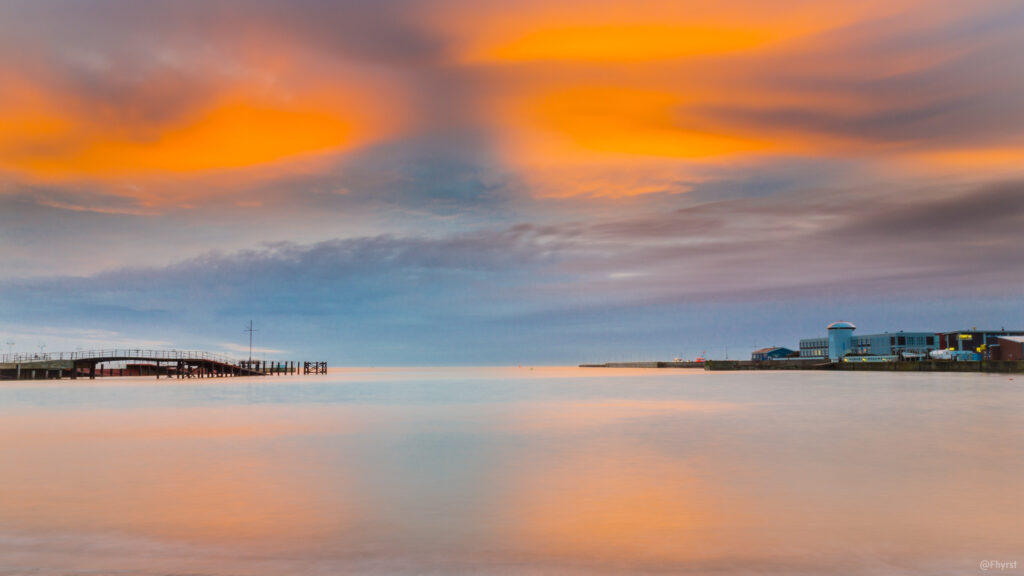 Abendhimmel über ruhigem Meer mit Steg
